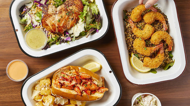 Three food containers filled with fish, shrimp and a lobster roll.