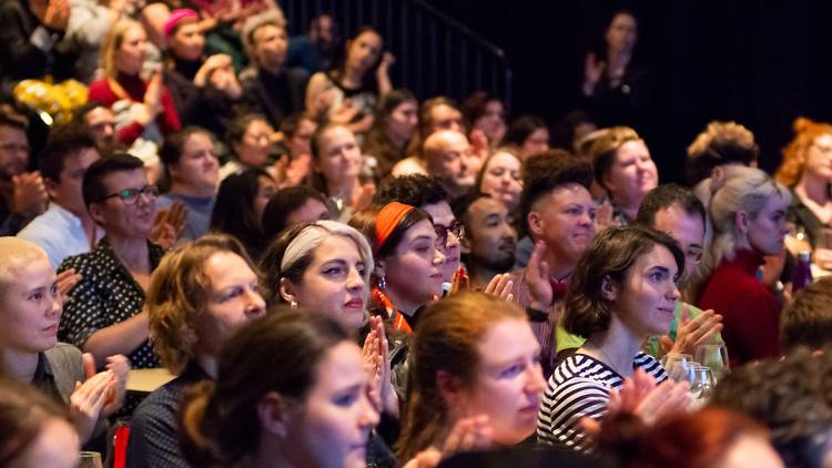 A crowd of people attentively watching a talk.