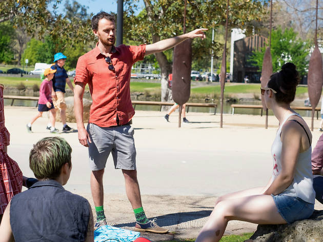 The Green Tour, Wayward Wanders A man in a t-shirt and shorts talking to people at Birrarung Marr