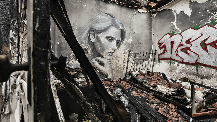 A mural of a woman thinking in an abandoned building