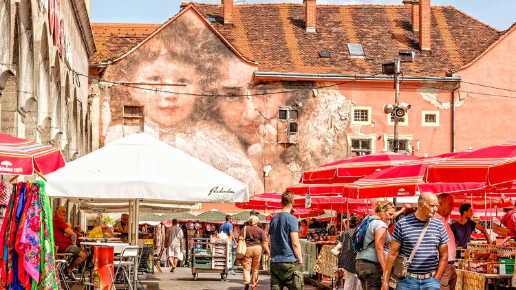 Springtime sales at Zagreb's Dolac marketplace overlooked by street art