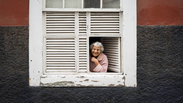 Older woman leaning out of window