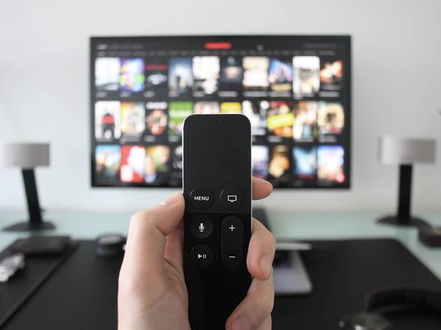 Hand holding remote watching Netflix Hand holding remote watching Netflix