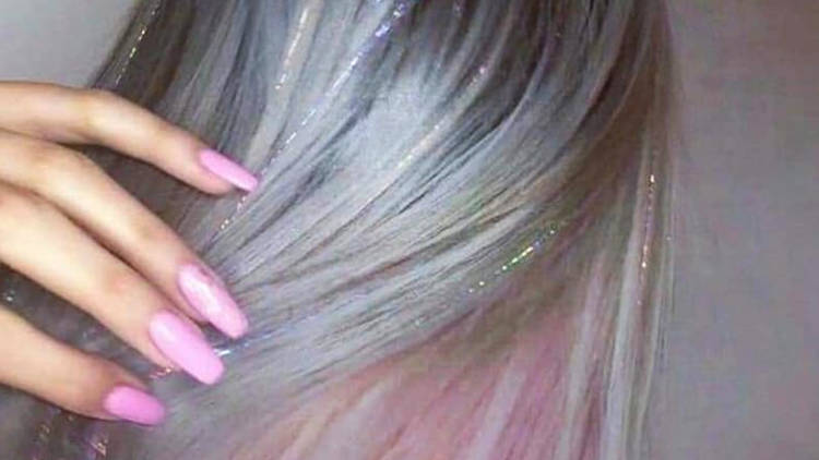 Mujer con extensiones de glitter y uñas rosa