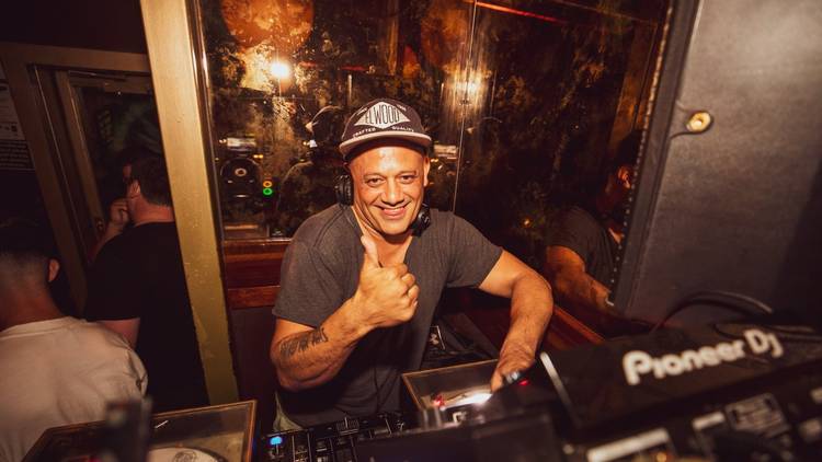 A DJ giving a thumbs up from behind the decks