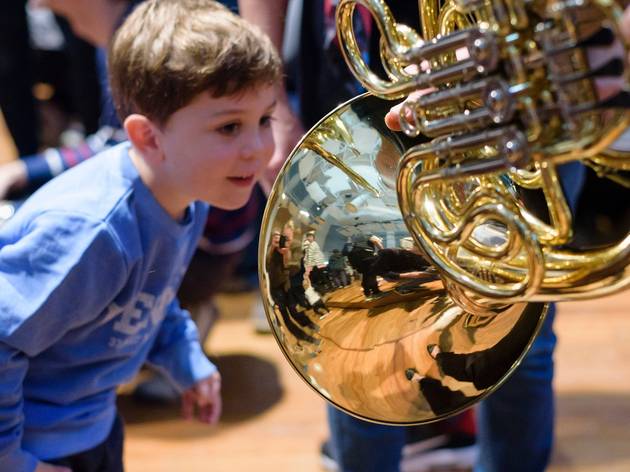 Jams for Juniors Small boy peering into a French horn