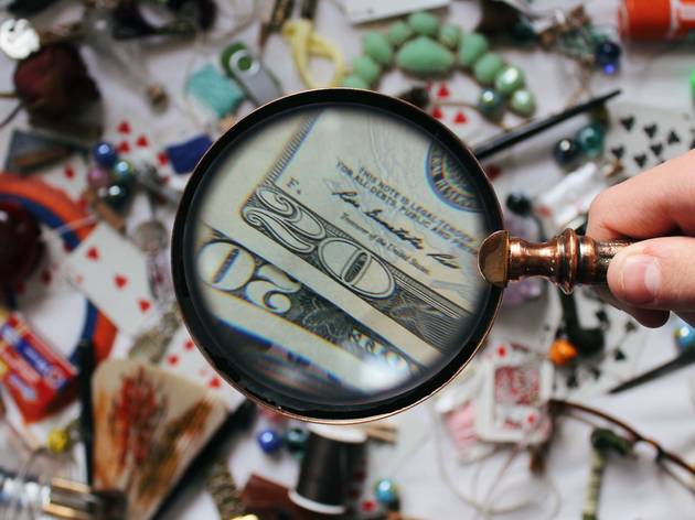 magnifying glass A magnifying glass is held over a table covered in miscellaneous objects.