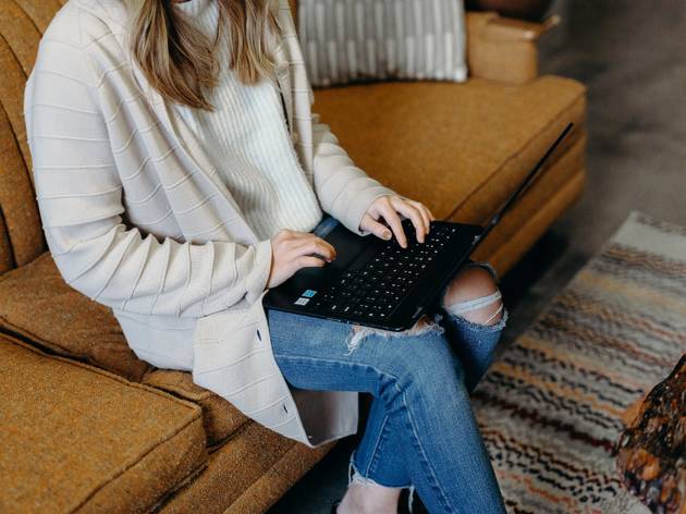 Woman using laptop on couch Woman using laptop on couch