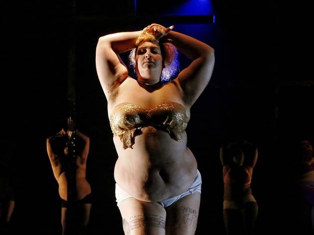 Nothing To Lose documentary A performer wearing white underwear and a gold decorated strapless bra looks defiantly at the camera, their arms raised above their head.