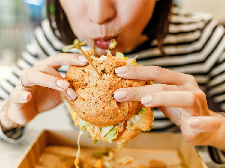 mujr comiendo hamburguesa