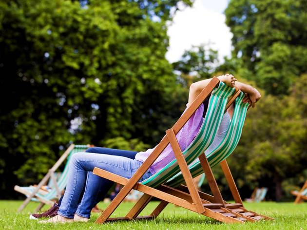 London’s heatwave set to continue next week with temperatures hitting 26C again couple sitting on deck chairs in St James Park