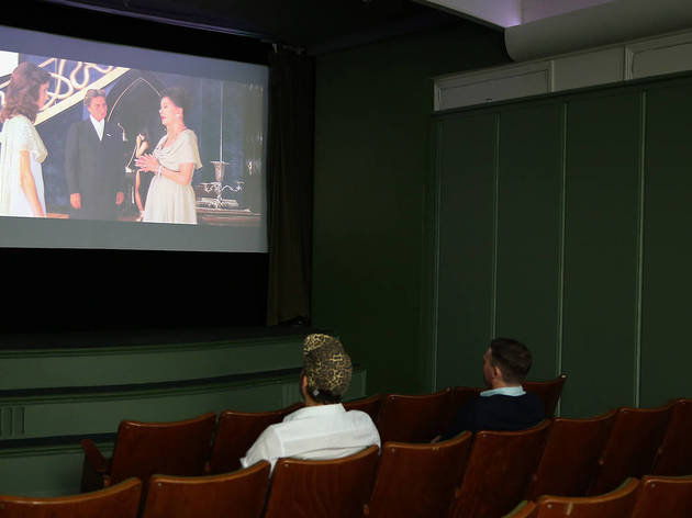Golden Age Cinema Two people sit in a small theatre watching a movie