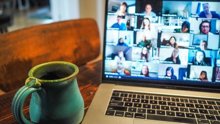 An online trivia game being played on a laptop next to a blue mug