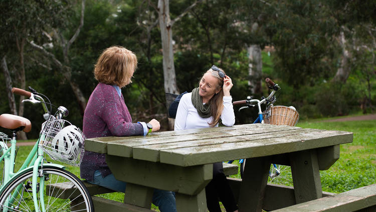 People sitting at bench at Werribee River Bike Trail