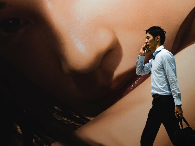 Man walking in front of mural on phone