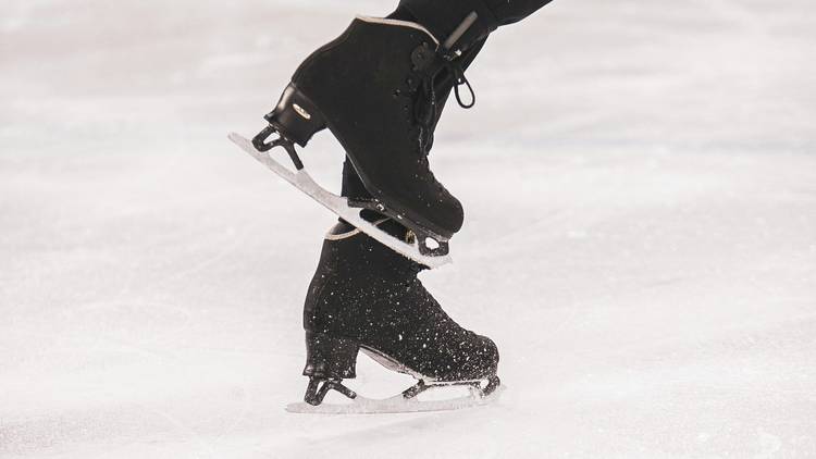 Feet in ice skates on rink