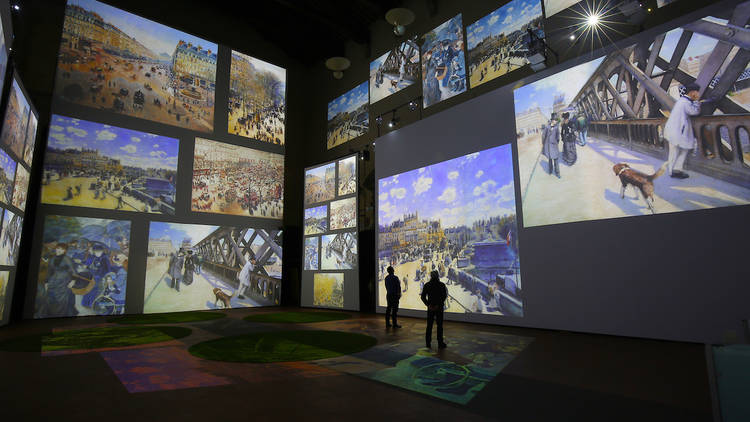 Sala de museo con pantallas que proyectan pinturas de Monet