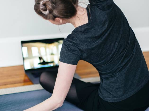 Generic stretch yoga online class Woman stretches in front of laptop