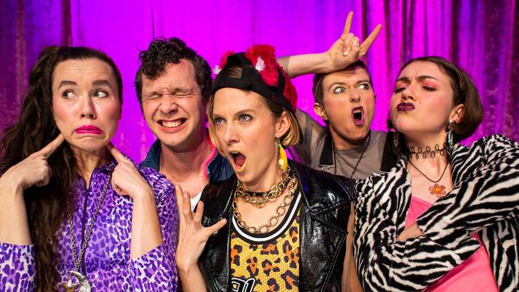 Five people making faces against a purple curtain backdrop