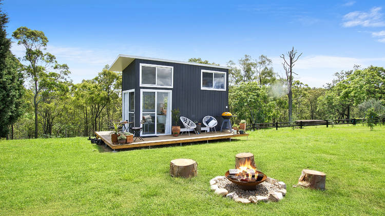 A tiny home on a very green lawn during the day