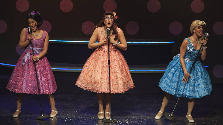 Tres actrices en el escenario con vestidos de los 50