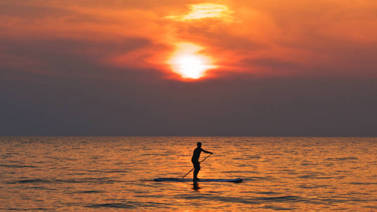 A solitary paddleboarder on the sea