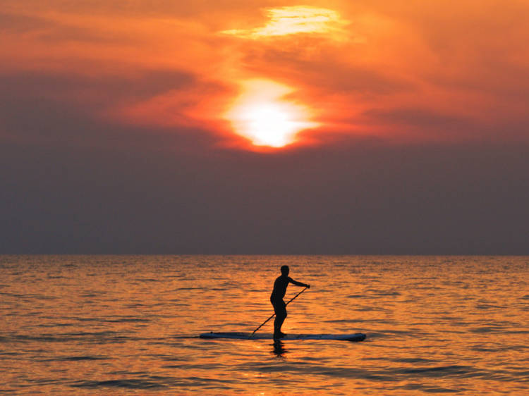 A solitary paddleboarder on the sea