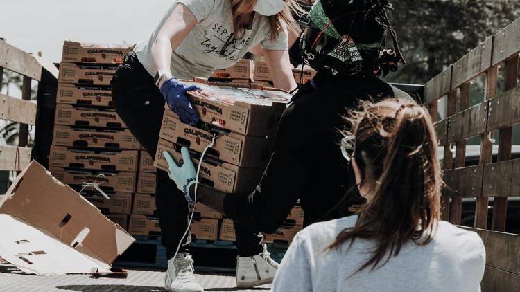 People unload crates from truck