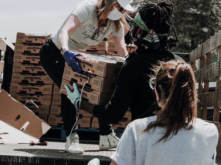 People unload crates from truck