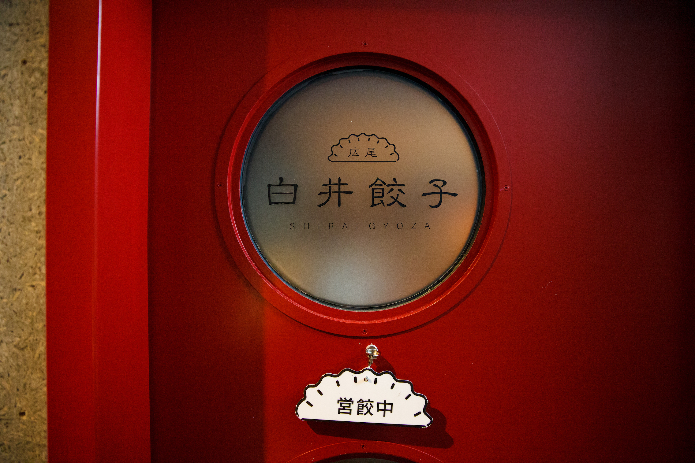 ドアプレートにかかる「営餃中」の文字がニクい