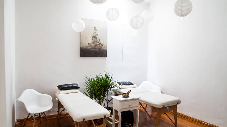 Interior de un cuarto de relajación blanco con camas de masaje