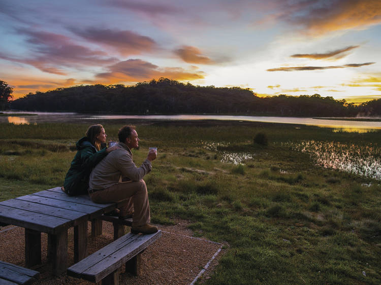 Two people sitting on a picnic table at Lake Catani