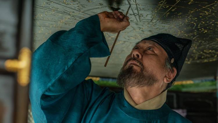 Korean man etching something above his head