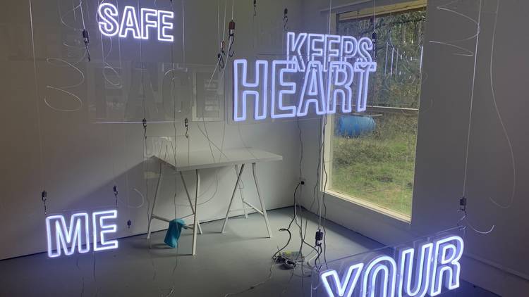 A room with neon words hanging in it