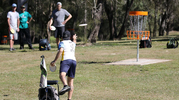 People playing disc golf in a park