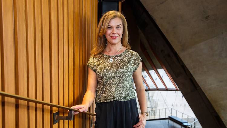 Woman standing with hand on railing in Opera House