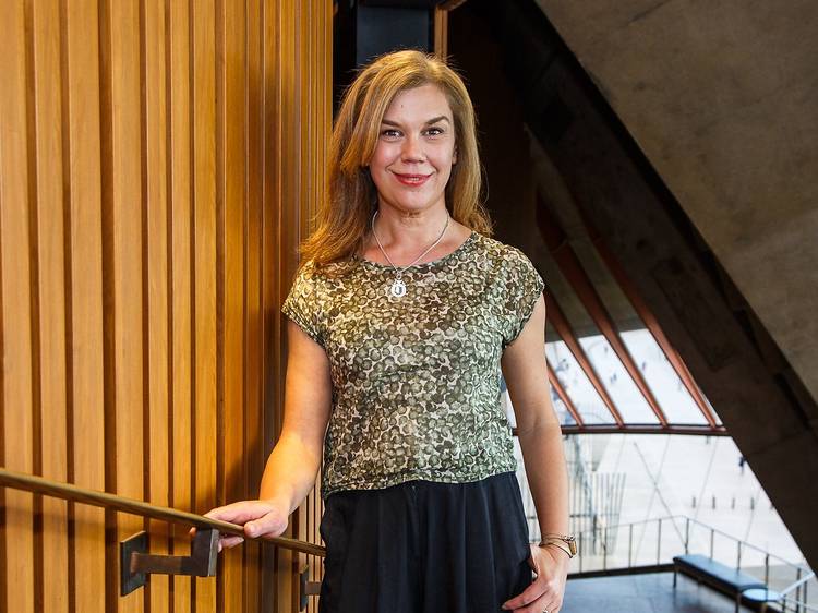 Woman standing with hand on railing in Opera House