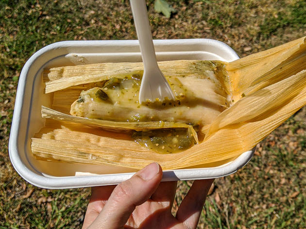 Keskipan tamale A tamale in a corn husk with green salsa