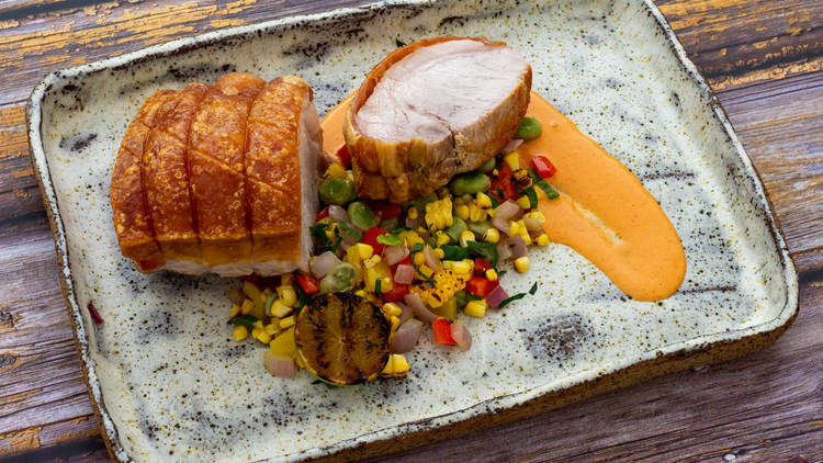 Riverview Farms roast pork with crackling on a plate with a charred corn salad
