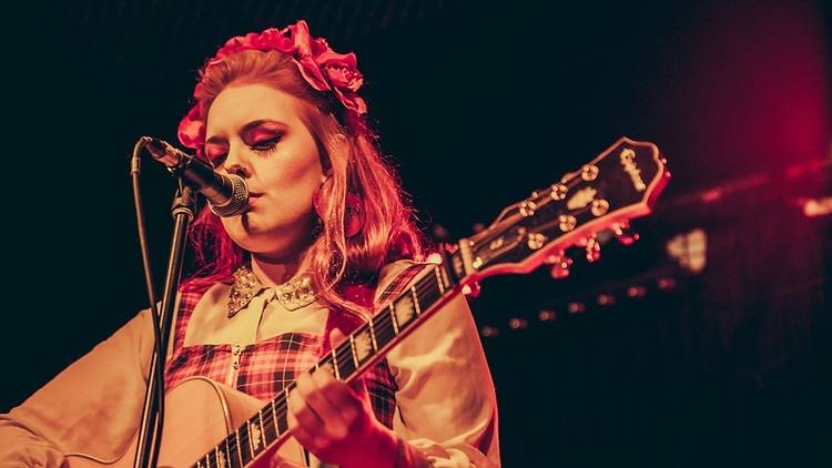 Alice Terry performs on stage with guitar