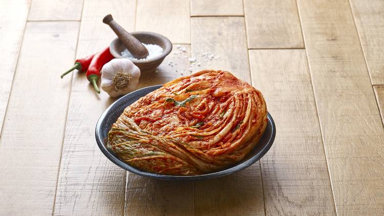 Bowl of kimchi with salt, garlic and chilli in the background