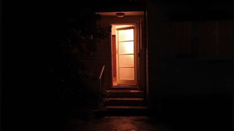 A lit doorway surrounded by darkness