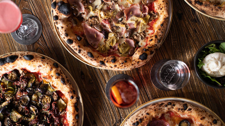 Pizzas and drinks on a wooden table