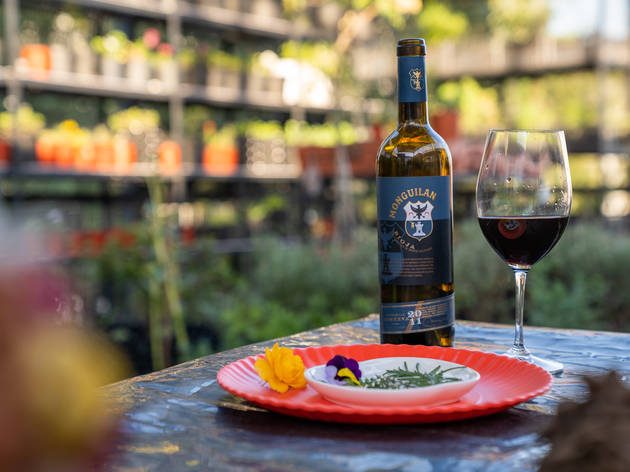 Huerto Urbano El Nido Botella de vino y copa sobre una mesa al aire libre