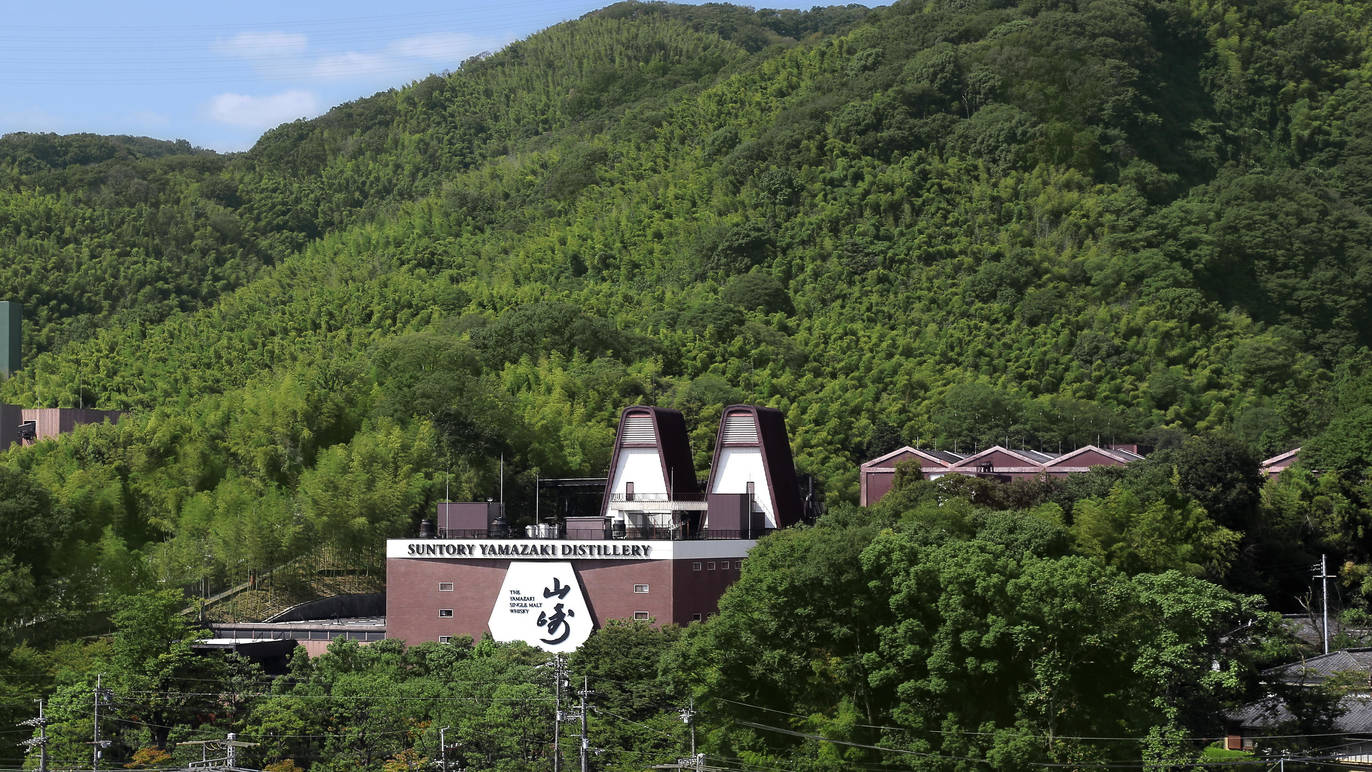 Yamazaki whisky distillery against a mountain forest backdrop