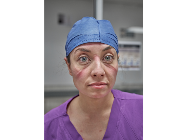 Retrato de médico en sala de urgencias Foto de médico en sala de urgencias con bata quirúrgica y marcas en el rostro