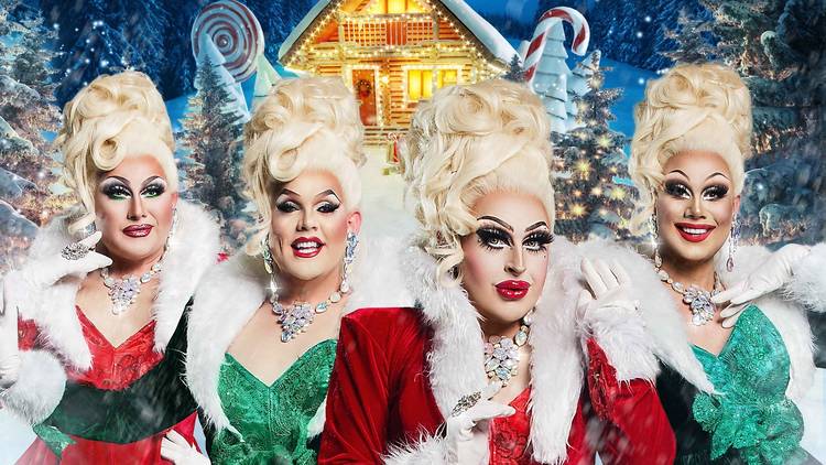 Drag queens dressed in Christmas costumes pose in a winter wonderland.