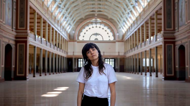 Indie rock star Courtney Barnett in white t-shirt and black jeans alone in Melbourne's beautiful Royal Exhibition Building