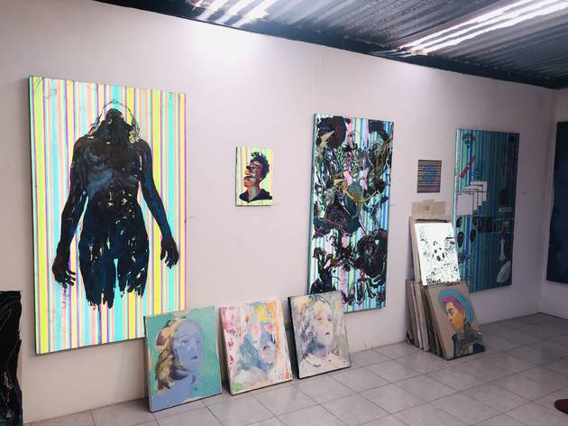 Estudio Santiago Cruz en San Miguel de Allende Interior de taller artístico con paredes rosa y pinturas colgadas