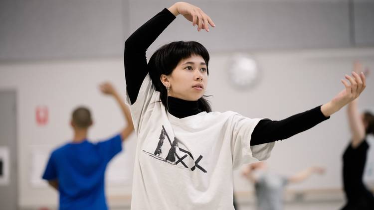 Young person in dance class wears black turtle neck sweater and loose tshirt.